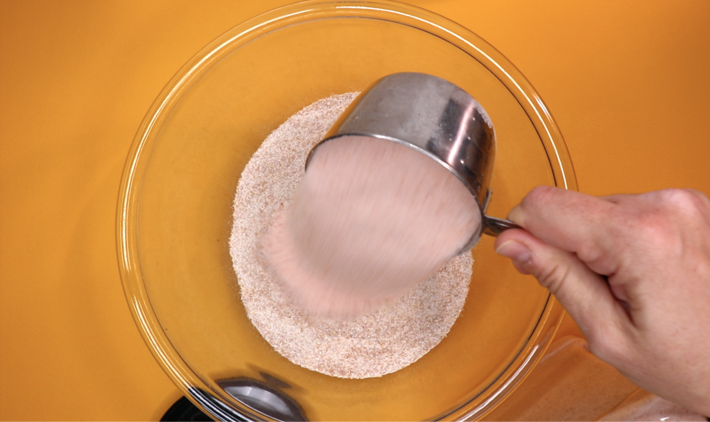Pouring salt into the mixing bowl for the salt dough dinosaur fossil experiment